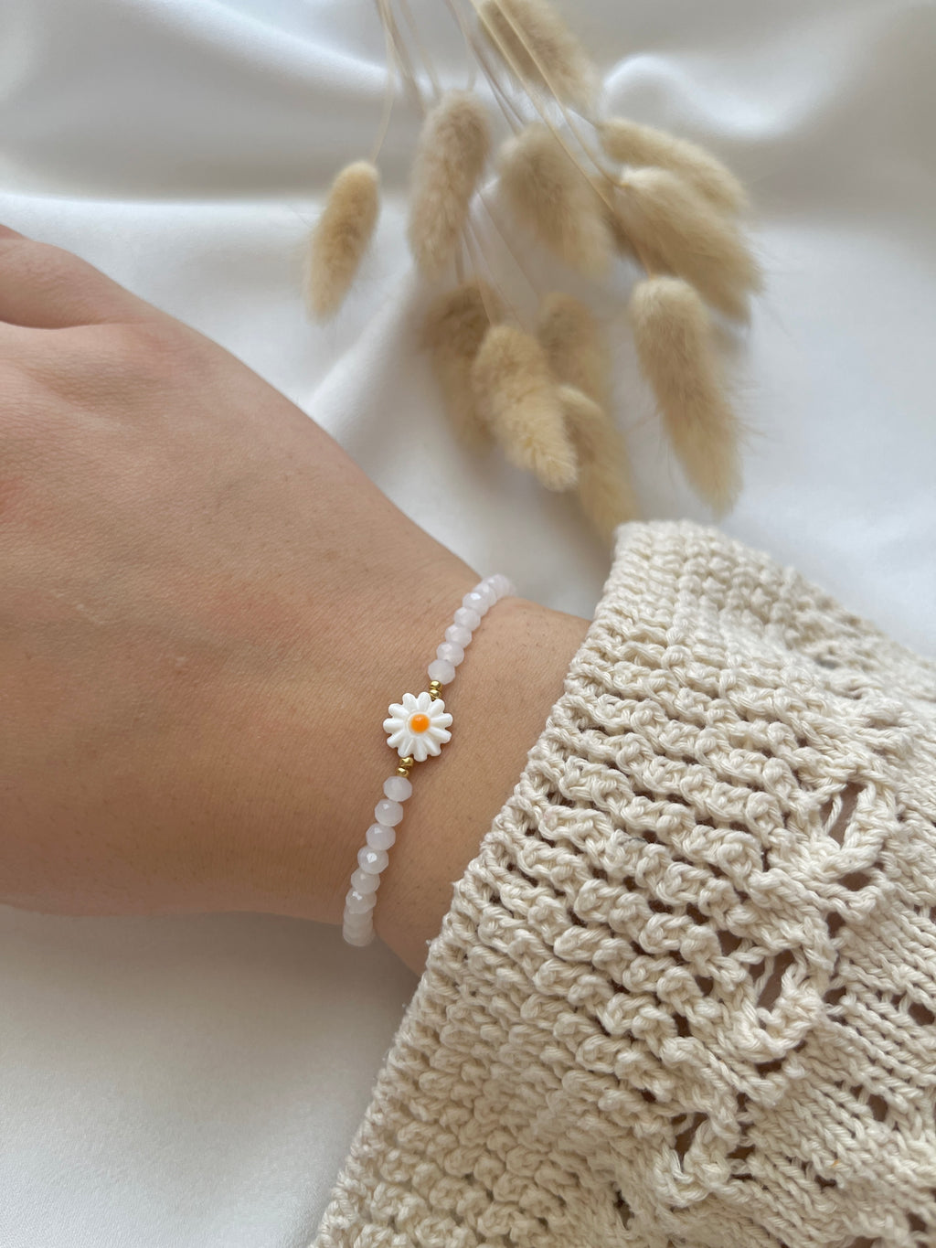 Perlenarmband aus weißen Kristallperlen und einer Perlmutt-Gänseblüme