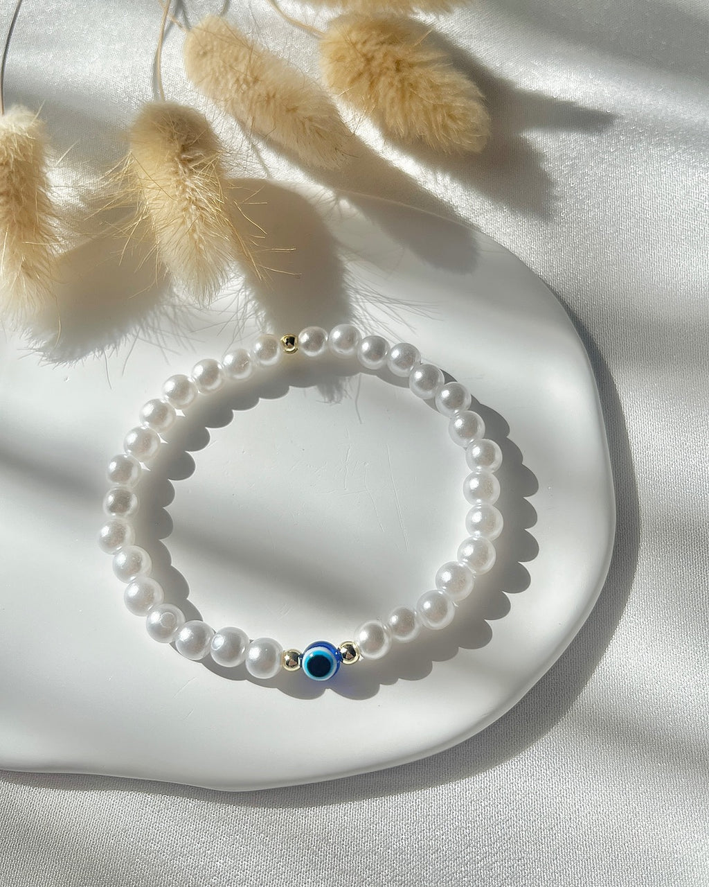 Perlenarmband aus weißen Perlen & Nazar