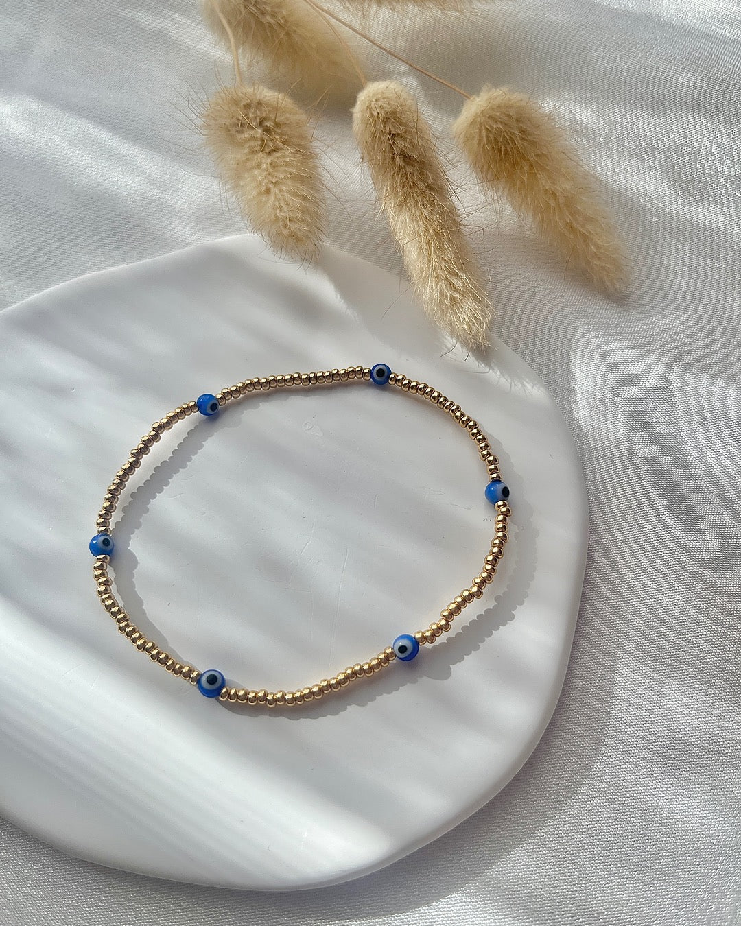 Perlenarmband aus goldenen Miyuki-Perlen & Nazar