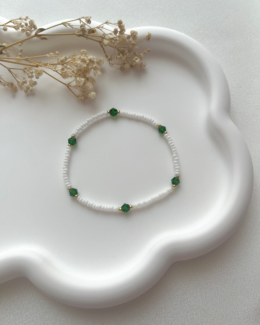Perlenarmband in Weiß mit dunkelgrünen Kristallperlen