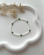 Perlenarmband in Weiß mit dunkelgrünen Kristallperlen