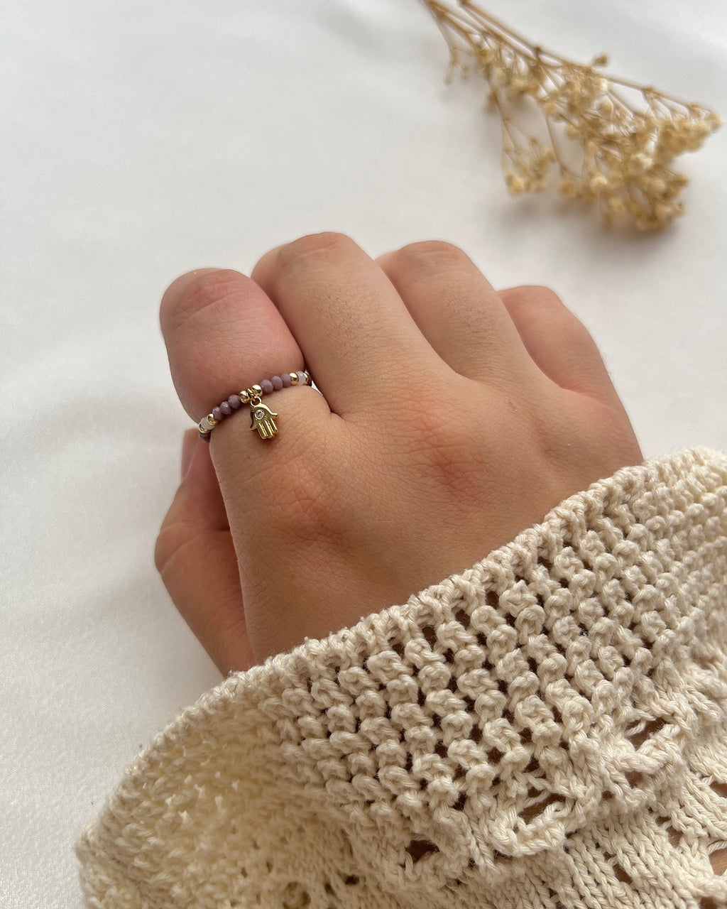 Perlenring aus lilanen Kristallperlen & Hand-Charm