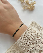 Perlenarmband in Smaragdgrün mit einer goldenen Blume