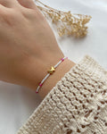 Perlenarmband in Weiß & Pink mit einem Schmetterling