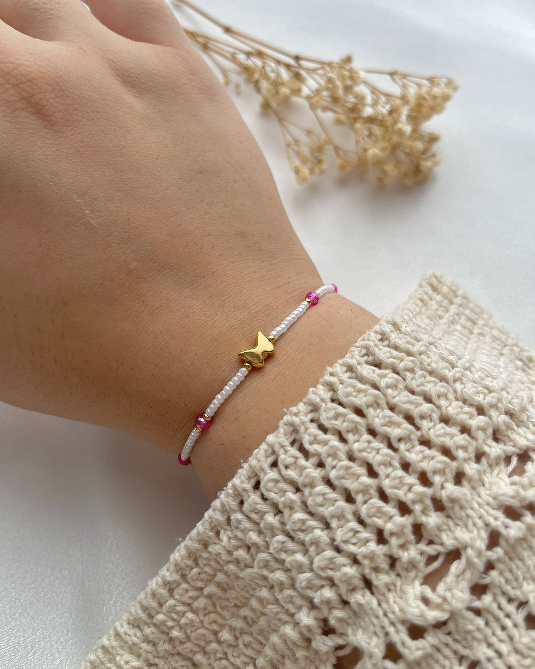 Perlenarmband in Weiß & Pink mit einem Schmetterling