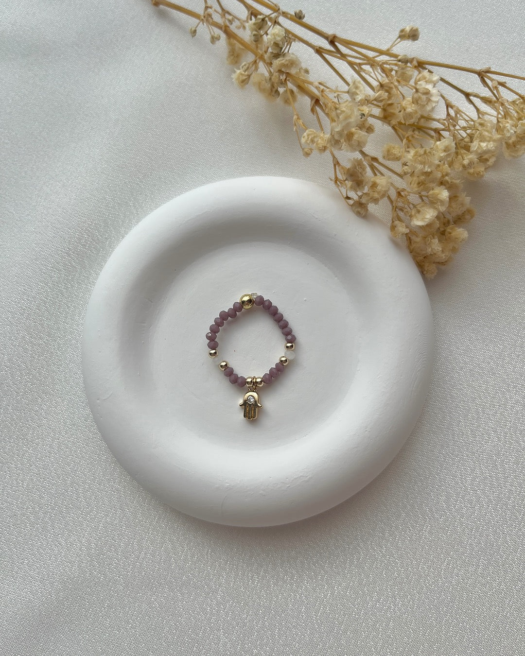 Perlenring aus lilanen Kristallperlen & Hand-Charm
