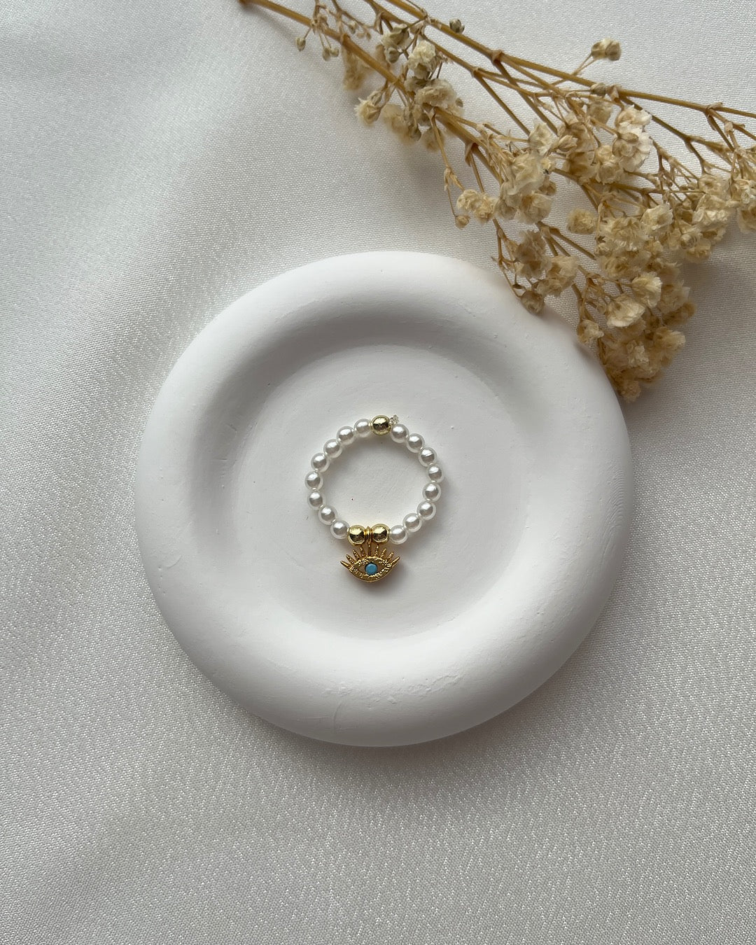 Perlenring aus weißen Glasperlen & Augen-Charm