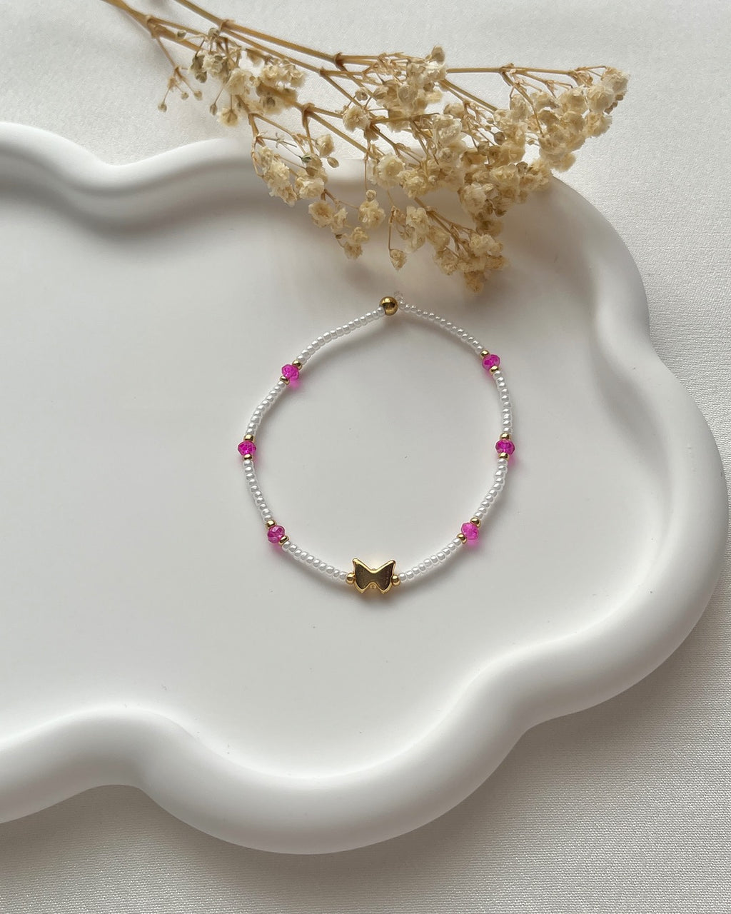 Perlenarmband in Weiß & Pink mit einem Schmetterling