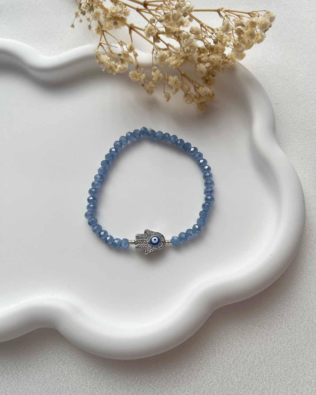 Perlenarmband in Blau & silberner Hamsa-Hand